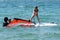 Instructors teach the child to ride windsurfing