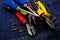 Instruments with bright colored handles lie on the denim. repair industry pliers pair of screwdrivers