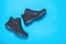 Insulated black casual men`s shoes on light blue background. Men`s shoes for cold weather. Flat lay