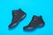 Insulated black sport men`s shoes on a light blue background. Men`s shoes for cold weather. Flat lay