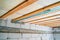 Insulated ceiling of a private house with a wooden crate. The roof is insulated with glass wool and sheathed with a vapor barrier