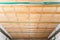 Insulated ceiling of a private house with a wooden crate. The roof is insulated with glass wool and sheathed with a vapor barrier