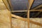 Insulation of walls and ceiling in the attic made of mineral wool between trusses, tied with polypropylene string.