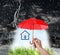 Insurance agent covering illustration with red umbrella during thunderstorm