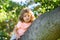 Insurance kids. Cute kid playing in the garden climbing on the tree.