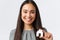 Insurance, loan, real estate and family concept. Close-up of happy smiling pretty asian woman showing small miniature of