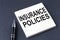 INSURANCE POLICIES text on the sticker with pen on the black background
