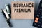 INSURANCE PREMIUM - words on brown paper on the background of a calculator, banknotes and pen