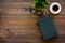 Intellectual entertainment concept. Books with empty cover near glasses, coffe, plant on dark wooden desk top view copy