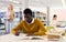 Intelligent african-american male student engaged in research working with books in university library