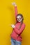 Intelligent Clever Winsome Smiling Caucasian Blond Girl In Coral Knitted Sweater Posing In Glasses While Pointing Direction With