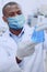 Intelligent male virologist holding a lab flask