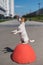 An intelligent obedient dog sits on its hind paws in a begging pose on anti parking concrete stone. Jack Russell Terrier