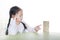 Intend little Asian child girl thinking to playing wood blocks tower game for Brain and Physical development skill in a classroom