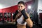 Intense action portrait at mma gym, female athlete training, posing with serious conviction in her eyes, fists up, ready to fight