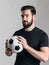 Intense lighting portrait of serious soccer player holding ball looking at camera