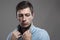 Intense moody portrait of young stubble man holding collar looking behind