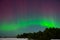 Intense northern lights aurora borealis over beach in Latvia