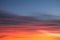 Intense, radiant orange cirrus clouds at dawn against a deep blue sky