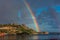 Intense rainbow rising above cliffs