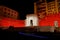 An intense red light illuminates Porta Livorno in the night