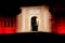 An intense red light illuminates Porta Livorno in the night