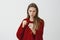 Intense serious woman ready to fight for love. Focused good-looking european female model in stylish red loose sweater