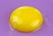 Intensive yellow egg yolk in closeup on purple background