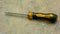 Interchangeable to torx plus head and flat head screwdriver with yellow handle on the floor