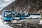 Intercity buses parked near the mountain forest at winter