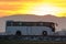 Intercity passenger bus driving on highway road in evening