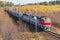 Intercity passenger train approaches to the station at autumn morning