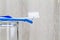 Interdental brush, toothbrush and dental floss on clean glass on blurred wooden background in bathroom