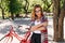 Interested caucasian girl in checkered shirt posing in park in summer day. Good-humoured blonde wom