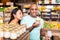 Interested couple reading product label on jar in supermarket