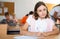 Interested diligent preteen schoolgirl writing exercises at lessons