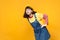 Interested girl teenager in french beret, denim sundress looking attentively, standing with arms akimbo isolated on