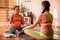 Interested impregnate lady having conversation with yoga trainer