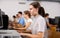 Interested teen girl studying with classmates in school class