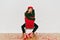 Interested woman with light-brown long hair posing on red chair. Bored young lady in high heel shoes sitting in elegant