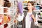 Interested young woman choosing colorful ribbons and braid for dressmaking in sewing supplies shop