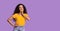 Interesting Offer. Pensive Asian Girl Looking Aside At Copy Space Over Purple Background And Playfully Smiling, Panorama