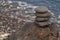 Interesting tower made of stones arranged on the shore of the ocean on a warm summer`s day