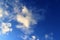 Interesting white and dark mixed cloud formations on a blue sky in spring