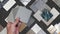 interior architect compare grainy quartz samples with ceramic tiles, artificial stones, marbles, stainless, quartz, terrazzo that