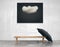 Interior art with a bench and a black picture of a cloud and umbrella