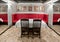 Interior banquet room with a large red sofa, table, chairs, mirrors and paintings