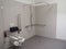 Interior bathroom featuring a white tiled shower stall with a toilet and handrail.