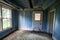 Interior of a blue room, abandoned and decaying, with a rotting floor and collapsing ceiling in Bannack Ghost Town in Montana