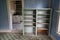 Interior of a blue room, abandoned and decaying, with a rotting floor and collapsing ceiling in Bannack Ghost Town in Montana